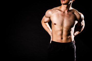 Obraz na płótnie Canvas sport man standing showing muscle bodybuilding on black backgrounds, fitness concept, sport concept