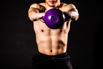 Fototapeta na wymiar sport man at fitness gym club doing exercise for arms with kettlebell and showing muscle bodybuilding on black backgrounds, fitness concept, sport concept