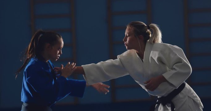 Beautiful girls are training on tatami sparring fighters. Testing techniques in the fight.