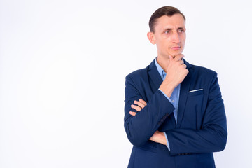 Studio shot of businessman in suit thinking and looking up