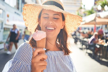 Young beautiful woman eating ice cream cone walking down the street of Tenerife on a sunny day of summer on holidays