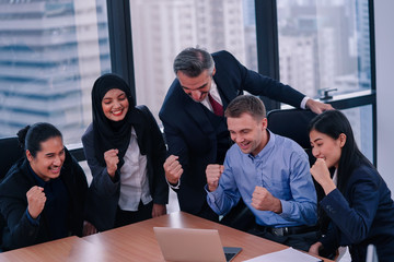 Fototapeta premium Business team celebrating with arms up after achieved the business goal.
