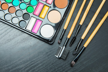 Variety brushes with makeup palette on the table