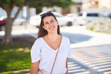 Young beautiful woman standing on the street smiling