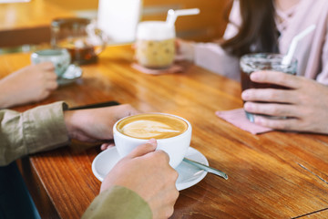 Closeup image of people enjoyed drinking coffee together in cafe
