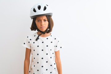 Beautiful child girl wearing security bike helmet standing over isolated white background skeptic and nervous, frowning upset because of problem. Negative person.