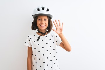Beautiful child girl wearing security bike helmet standing over isolated white background showing and pointing up with fingers number five while smiling confident and happy.
