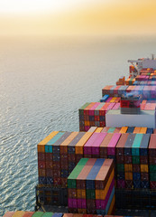 top aerial view of the large volume of TEU containers on ship sailing in the sea carriage the...