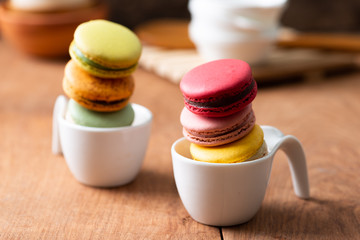 Pile of sweet and colourful french macaroons on wood background.