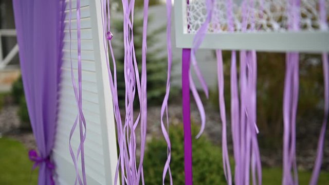 Wedding ceremony decoration on wind. Wind blows colorful ribbons in spring sunlight