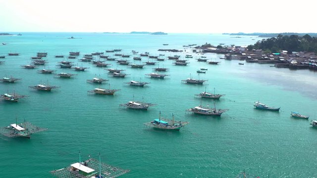 Aerial view of drone fliying over fishing boat at Tanjung Binga fishing Village in Belitung Island Indonesia. Fishing Boat on Clear water.