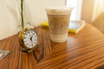 Alarm clock with iced coffee on table at cafe