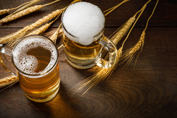 Glasses of Light Beer with wheat on the wooden table, copy space for your text
