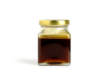 ็Honey dipper and Natural  honey in jar on white background.