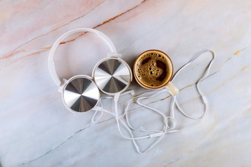 Headphones with cup of coffee espresso on marble background