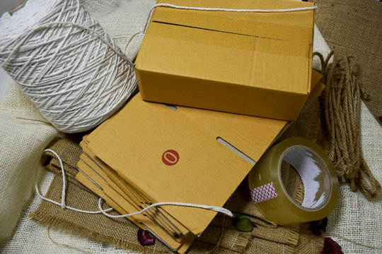 Paper box for mailing Rope for strapping box, scissors and plastic sheet shockproof. Put on a sack of cloth.