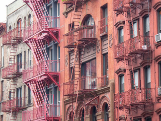 Obraz premium Facades of historic buildings in the Soho district of New York. The characteristic iron safety stairs on the facades