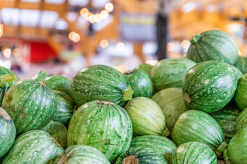 Round zucchini pile, being sold at a farmer's market. Also referred to as round courgette. Unique, heirloom zucchini variety.