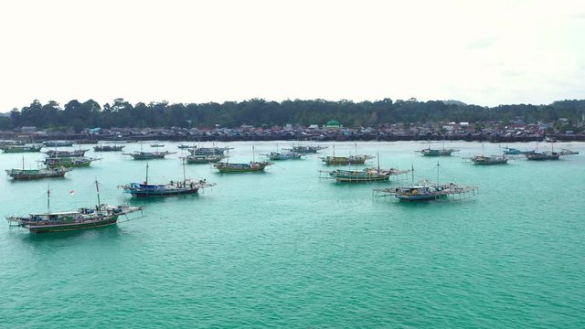 Aerial view of drone fliying over fishing boat at Tanjung Binga fishing Village in Belitung Island Indonesia. Fishing Boat on Clear water.