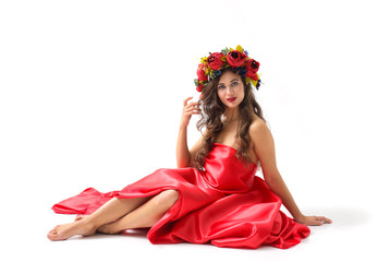 beauty portrait of a young woman with a wreath of red roses on her head