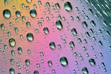 Water drops with reflection of the rainbow. Colorful abstract background. Blue, green, red and...