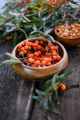  Leaves and berries of orange sea ​​buckthorn on wooden table background