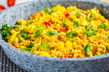 Tofu scramble with vegetables in a pan. Vegan Alternative Omelet.