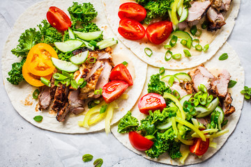Healthy mini tortillas with grilled chicken, meat, fresh vegetables  on light grey background, top view.