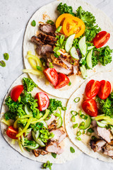 Healthy mini tortillas with grilled chicken, meat, fresh vegetables  on light grey background, top view.