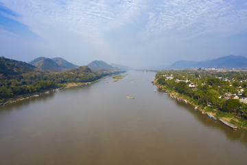 Fototapeta premium View from above, stunning aerial view of the beautiful Luang Prabang city with the Mekong River flowing through. Luang Prabang is the ancient capital of Luang Prabang Province in northern Laos.