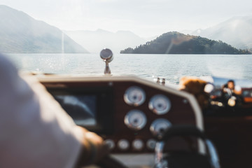 Lake Como mountain view through yacht window. Silhouettes of hills on horizon. Luxury vacations and...