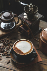 Coffee cup and coffee beans on a wooden table and sack background,Vintage color tone.