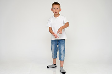 Full-length portrait on a white background of a cute boy child with Vitiligo disease - a violation...