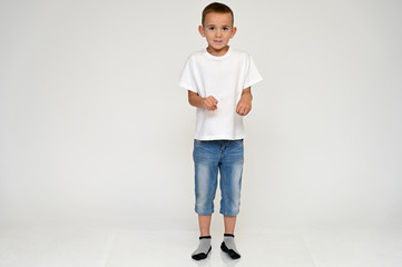 Full-length portrait on a white background of a cute boy child with Vitiligo disease - a violation...