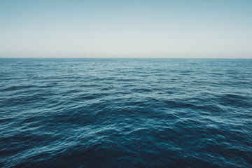 Calm sea surface with waves at sunny day - ocean background