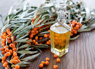 Leaves and berries of orange sea ​​buckthorn on wooden table background