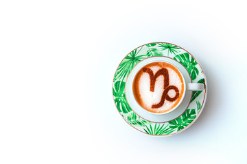 A cup of cappuccino coffee with a zodiac sign