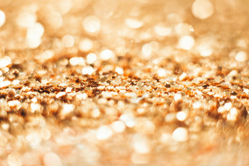 Gold Christmas background from sparkles. Blurred abstract textures.