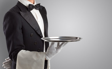 Waiter serving with white gloves and steel tray in an empty space