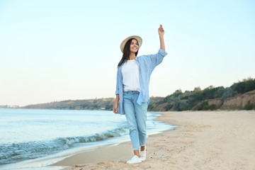 Fototapeta na wymiar Beautiful young woman in casual outfit on beach