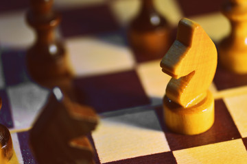 Chess figures on a wooden chessboard close up, retro style