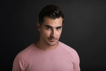 Portrait of handsome young man on black background