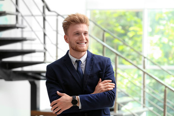 Portrait of handsome young man in elegant suit indoors