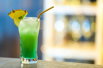 Fresh alcoholic cocktail with pineapple and lemon on bar counter, space for text