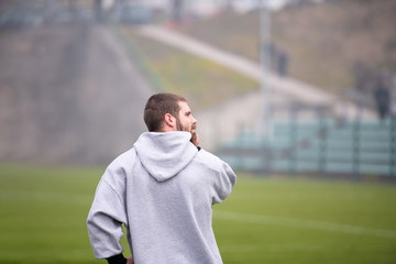 american football player warming up and stretching