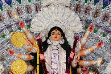 Fototapeta na wymiar Goddess Durga idol at decorated Durga Puja pandal, shot at colored light, at Kolkata, West Bengal, India. Durga Puja is biggest religious festival of Hinduism and is now celebrated worldwide.
