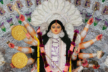 Goddess Durga idol at decorated Durga Puja pandal, shot at colored light, at Kolkata, West Bengal, India. Durga Puja is biggest religious festival of Hinduism and is now celebrated worldwide.