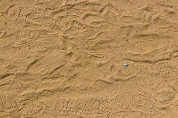 Fototapeta na wymiar Sandy ground with many footprints