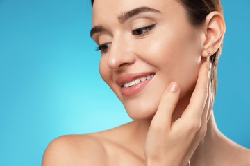 Obraz premium Beautiful woman with perfect smooth skin on light blue background, closeup