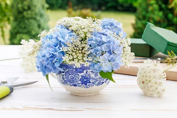Fototapeten Wie man ein Blumenarrangement mit blauer Hortensie (Hortensie) und weißer Queen-Anne-Spitze macht © agneskantaruk